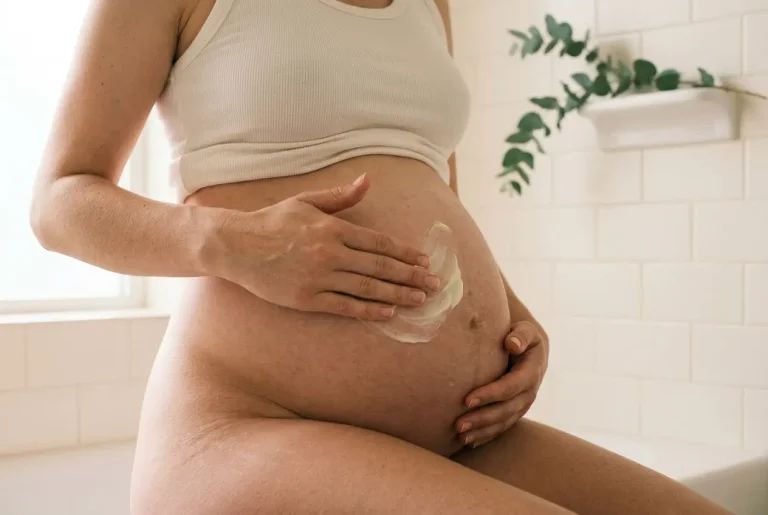 Femme enceinte appliquant une crème sur le ventre nu, douceur et soin naturel pendant la grossesse, attitude femme enceinte.